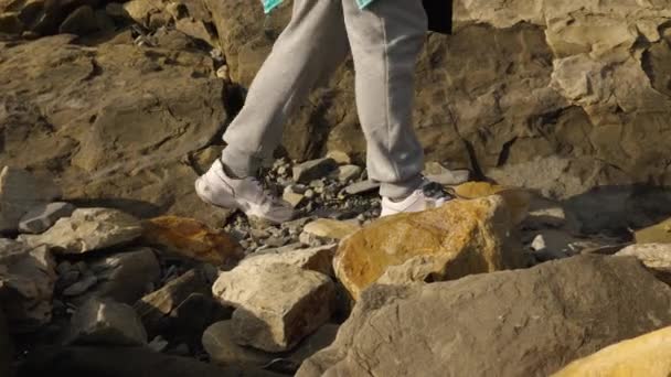 여자들의 다리는 바지를 바위에 기대어걸어 다닌다 사이드 카메라는 다리에 평행하게 — 비디오