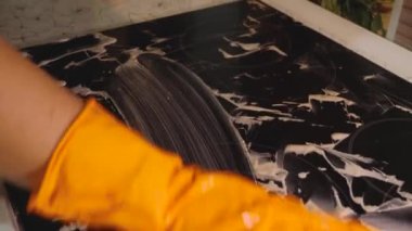 Ocağın üstünü sünger ve deterjanla yıkıyorum. Seçici Odaklanma. Elektrikli sobanın ev temizliği kavramı. Yakın plan. Rusya, Krasnodar, 3 Ekim 2021