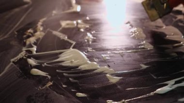 Ev mutfağını metal bir kazıyıcıyla temizliyorum. Hob beyaz bir temizleyiciyle kaplanmış.