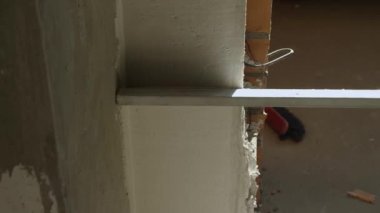 Alçılı bir duvar alüminyum bir kuralla yerle bir ediliyor. Oda bitirme konsepti