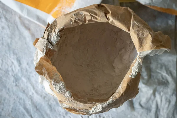 Alçılı bir kesekağıdının üst görüntüsü. Yarısı dolu bir çantada kuru karışım. Oda yenileme konsepti