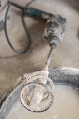 Çamurlu su kovasının üzerine kuru mikser hortumuyla sert bir yumruk. Seçici Odaklanma. Tamir ve onarım konsepti