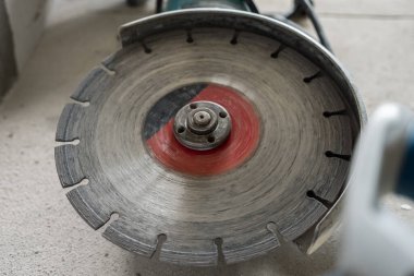 Açı öğütücüdeki beton üzerindeki çizik diskin yakın çekimi. Seçici odaklanma. Oda yenileme konsepti