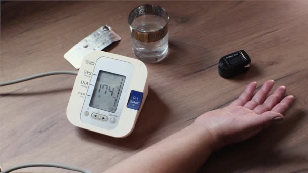 Ett Träbord Finns Blodtrycksmätare Ett Glas Vatten Och Piller Äldre — Stockvideo