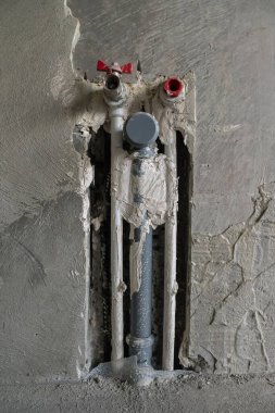 Beton duvarda üç plastik boru var. Soğuk ve sıcak su için iki tane. Üçüncüsü kanalizasyon için. Bir boruda musluk, diğerinde tıkaç var. Tesisin onarımı konsepti.