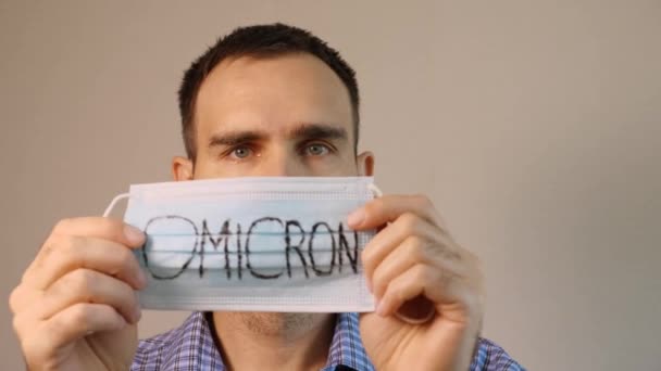 Uomo Caucasico Indossa Una Maschera Medica Blu Con Scritto Omicron — Video Stock