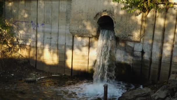 Zpomalený záznam vypouštění odpadních vod z čistírny odpadních vod do řeky. Detailní záběr. Koncept ekologie. — Stock video
