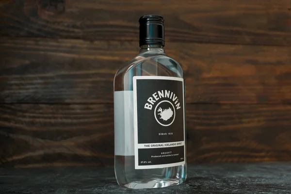 500 ml 'lik yeni bir Brennivin şişesi yarım dönüşle koyu ahşap bir arka planda duruyor. Geleneksel İzlanda ruhları. Rusya, Krasnodar, 6 Aralık 2021