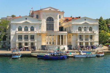 Sivastopol Körfezi 'nden Lunacharsky' nin adını alan Drama Tiyatrosu manzarası. Suda zevk tekneleri var, insanlar setin üzerinde yürüyor. Kırım Yarımadası, 25 Temmuz 2015