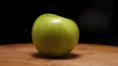 Ahşap bir arka planda olgun bir elma. Kamera etrafta uçuyor. Parallaks etkisi. Renet simirenko türünden bir elma. Yakın plan.