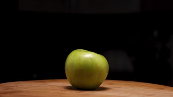 Una Manzana Verde Sobre Una Tabla Madera Sobre Fondo Negro — Vídeos de Stock