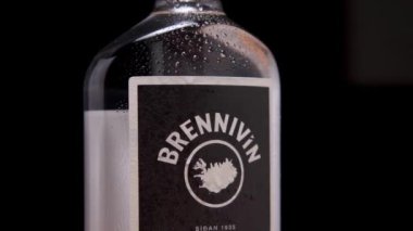 Bir şişe Brennivin 'in etiketini kapatıyoruz. Arka planda yoğunlaşma damlacıkları var. İzlanda ruhları