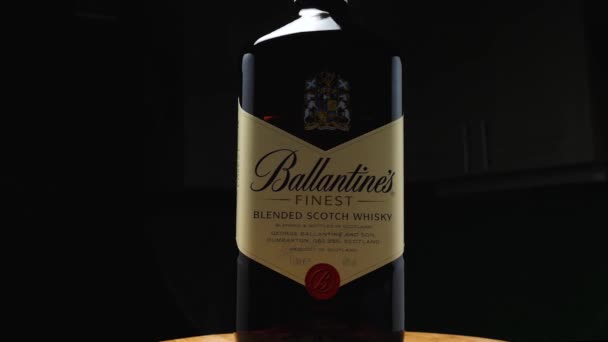 Bir litre Ballantine 'ın yakın çekimi. Arka planda koyu renk bir viski. Kamera etrafta uçuyor. Parallaks etkisi. — Stok video