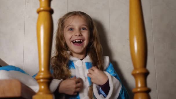 Krásná Blonďatá Holčička Modrém Rouchu Směje Otevřenou Pusou Sedící Doma — Stock video