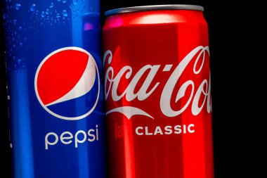Siyah arka planda mavi bir kutu Pepsi ve kırmızı bir kutu Coca-Cola yakın plan. Rusya, Krasnodar, 15 Aralık 2021