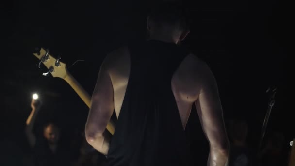 Close Bass Player Playing Front Audience Shines Flashlights Him Back — Vídeo de Stock