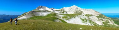 Panorama of a mountain landscape. Two people, a guy and a girl go to Oshten. The mountain is in the south of Russia