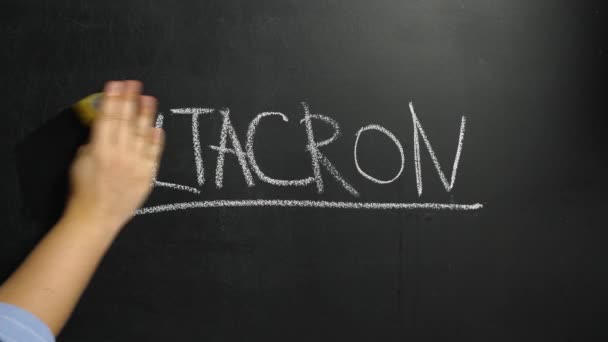 一个女人的手擦掉了写在黑板上的用粉笔写着的一个字 德尔塔克伦 这个字是用黄色的湿海绵写的 Deltacron是Coronovirus感染Covid 19的一个新变种 — 图库视频影像