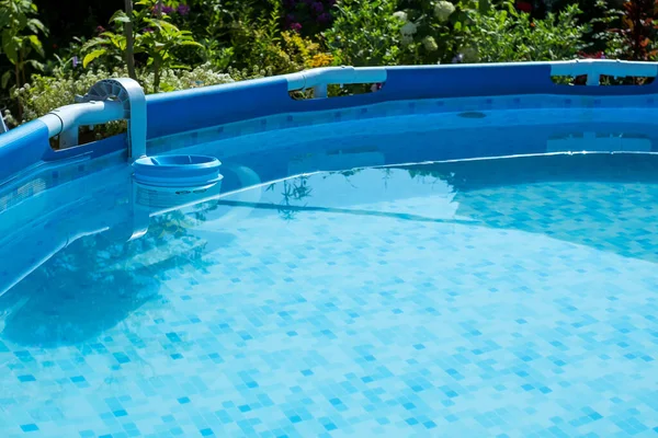 圆形框架游泳池 后院有清澈的蓝水 背景中的花朵 — 图库照片