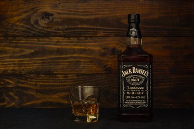 Bir şişe Jack Daniels Eski 7 numaralı Amerikan viskisi ve koyu ahşap arka planda buzlu bir bardak. Jack Daniels dünyaca ünlü bir viskidir. Rusya, Krasnodar, 11 Aralık 2021