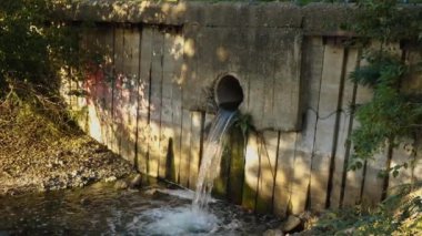 Atık suyun borudan nehre boşalmasının yavaş çekim görüntüleri. Ekoloji kavramı. Rusya, Krasnodar, 13 Ekim 2021