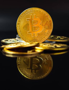 Bir avuç dolusu BTC bozuk para kulesinin üzerinde kara arka planda ayna resmi olan bir Bitcoin para kulesi. Engelleme teknolojisi