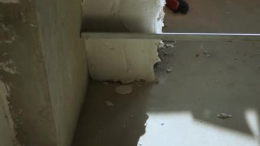 Duvardaki taze alçıların hizalanmasına yakın çekim. Oda bitirme konsepti