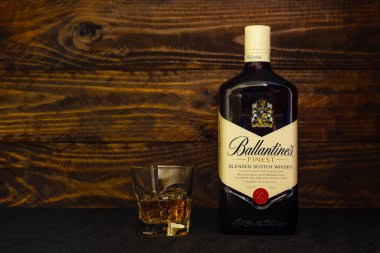 Bir şişe Ballantine 's Best Scotch Whisky ve koyu ahşap arka planda buzlu bir bardak. Orijinal karıştırılmış viski, ilk olarak 1910 'da yapılmış. Rusya, Krasnodar, 11 Aralık 2021
