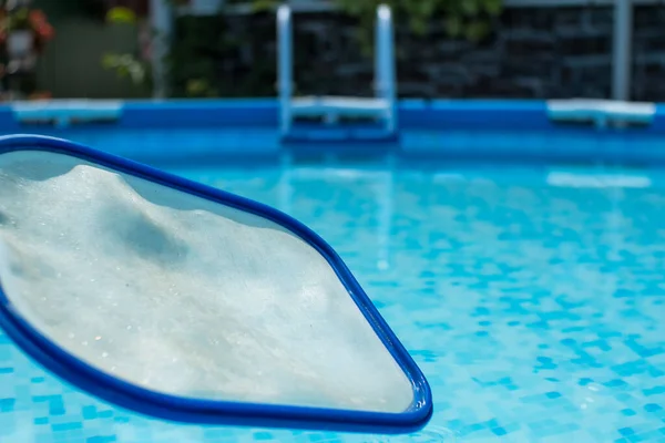 在清澈的蓝水背景下 一个游泳池里的叶网滑翔机的特写 圆框池和池略读网 — 图库照片