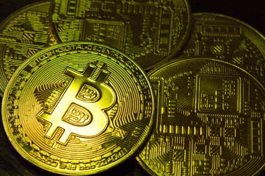 Koyu arkaplanda beş tane BTC madeni para var. Bitcoin şifreli para birimi. Engelleme teknolojisi. Yakın plan.