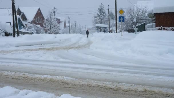 Een Man Loopt Een Besneeuwde Weg Drijven Sneeuwvlokken Aan Randen — Stockvideo