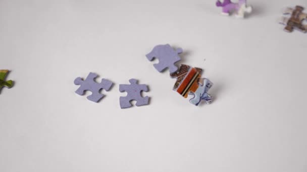 Pezzi Del Puzzle Cadono Casualmente Sullo Sfondo Bianco Riempiendolo Stessi — Video Stock