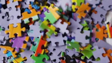 Başka bir yapbozun renkli parçalarıyla birlikte düşen yapboz parçalarına yakından bakın. Yavaş çekim