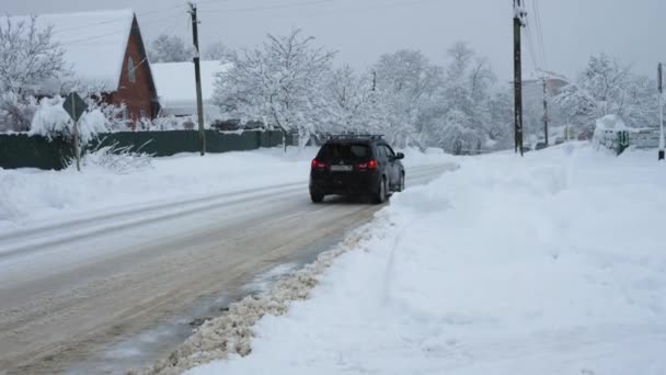 汽车在雪地的路上行驶 后视镜背景是房屋 灰色的冬季天空和降雪 俄罗斯 Goryachiy Klyuch 2022年2月5日 — 图库视频影像