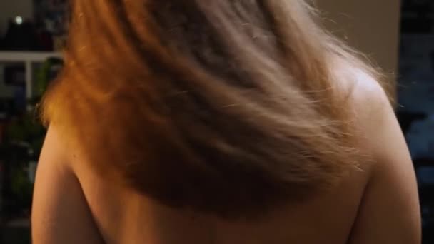 一个女人摇她长长的蓬松的头发的特写镜头 从后面看 慢动作摄像机从底部移动到顶部 — 图库视频影像