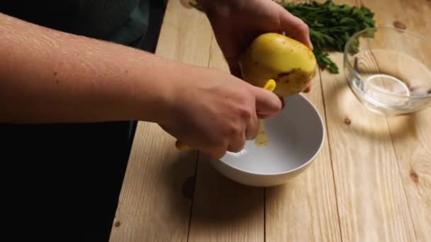 Vrouwenhanden Schillen Aardappelen Met Een Aardappelschiller Schil Van Groente Valt — Stockvideo