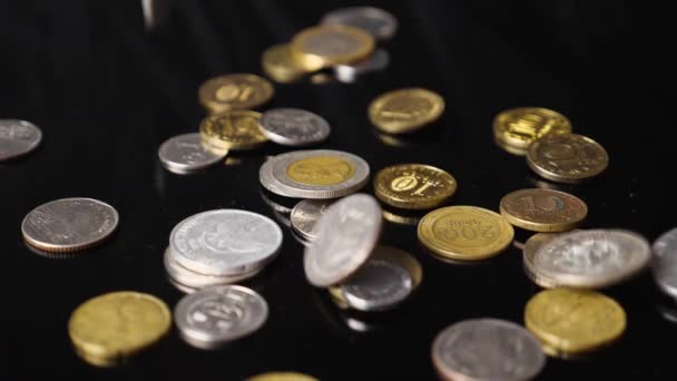 Close-up de moedas de diferentes países do mundo caindo contra um fundo preto em câmera lenta. O conceito de uma crise financeira global. — Vídeo de Stock