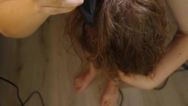 Vista dall'alto di una donna che si asciuga i capelli con un asciugacapelli piegato a metà. Primo piano, concentrazione selettiva. Il concetto di bellezza e cura dei capelli. — Video Stock