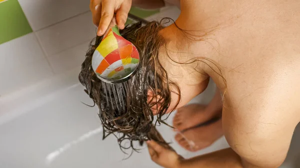 위에서 내려다보면 안에서 굽히고 머리를 여자가서 샤워실 줄기흘러나와 머리카락에서 샴푸를 — 스톡 사진