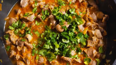 Maydanoz manzarası ve tavuklu sebzeli tavuk midesi tavada pişiyor. Yakın plan. Asya usulü yemek.