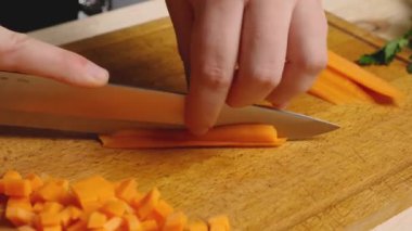 Kesme tahtasındaki havuçları bıçakla jülyen renginde doğramak. Malzemelerin hazırlanması. Her gün sağlıklı ve sağlıklı yiyecekler.