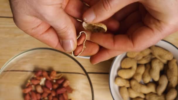 Närbild Mans Hand Som Skalar Rostade Jordnötter Från Sina Skal — Stockvideo