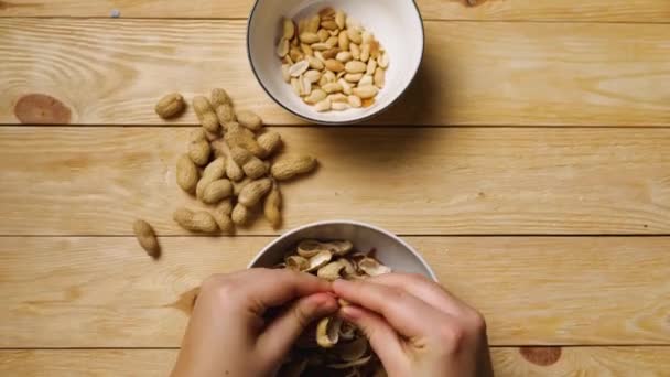 Großaufnahme Von Frauenhänden Die Erdnüsse Über Schüsseln Schälen Eine Handvoll — Stockvideo