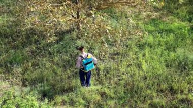 Yüzünde maske olan genç bir adam ceviz ağacı tarlasına bitki ilacı püskürtüyor. İHA görüntüsü. 4 bin. Bargota, Navarra, İspanya, Avrupa.