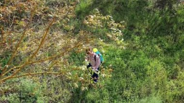 Yüzünde maske olan genç bir adam ceviz ağacı tarlasına bitki ilacı püskürtüyor. İHA görüntüsü. 4 bin. Bargota, Navarra, İspanya, Avrupa.