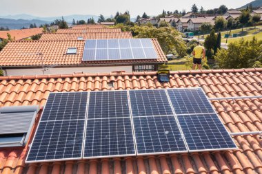 İşçi çatıya güneş panelleri kuruyor. İHA görüntüsü. 4 bin. Navarre, İspanya, Avrupa. Çevre ve teknoloji kavramları.