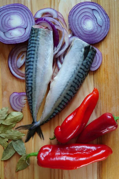 Delicious fish cut on a board, mackerel, herring. Fresh vegetables