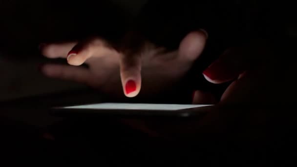 Uma garota no escuro está enviando mensagens em seu smartphone — Vídeo de Stock