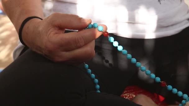 女人拿着一条玛瑙项链祈祷的细节 — 图库视频影像