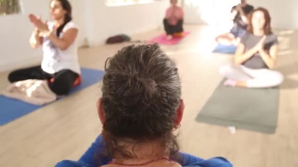 身穿蓝色衣服的瑜伽老师在冥想时伸出胳膊 从家里教她的学生 — 图库视频影像